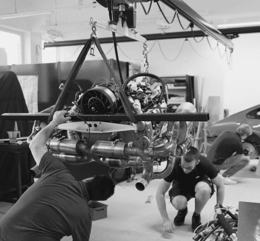 The rebuilt flat-six engine lowered into place by the workshop crew